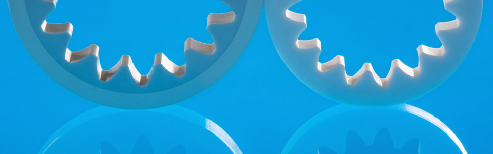 Zwei graue Ringe mit zahnradförmigen Löchern vor blauem Hintergrund, die nur zur Hälfte zu sehen sind.
