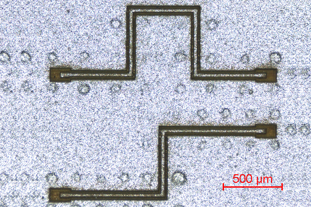 Laser-structured coplanar cable with angulations and 30 µm wide inner conductor.