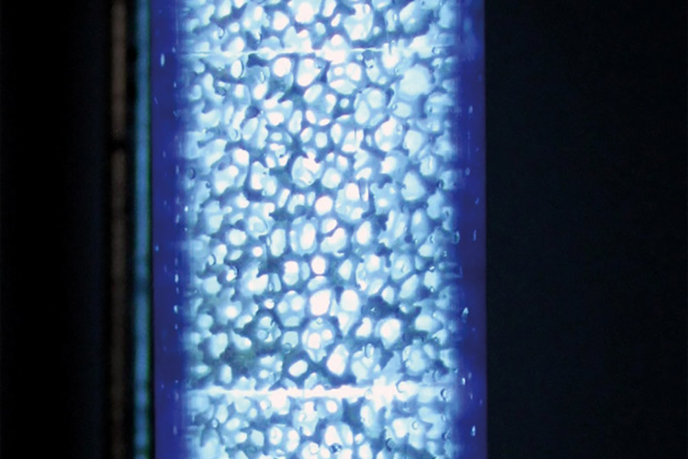 Cellular ceramics under UV-C irradiation in an experimental reactor.